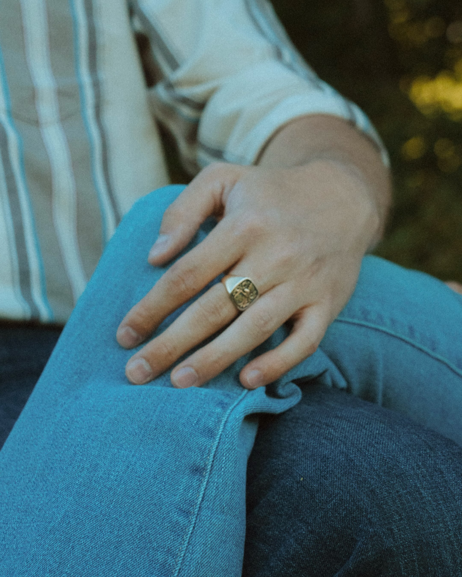 Hand mit Ring auf dem Knie